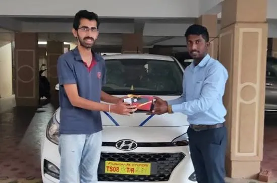 Happy customer receiving the key for their newly serviced and decorated black Scorpio SUV.