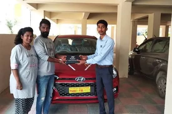 Owner celebrating key handover for their newly serviced grey Maruti Suzuki sedan.